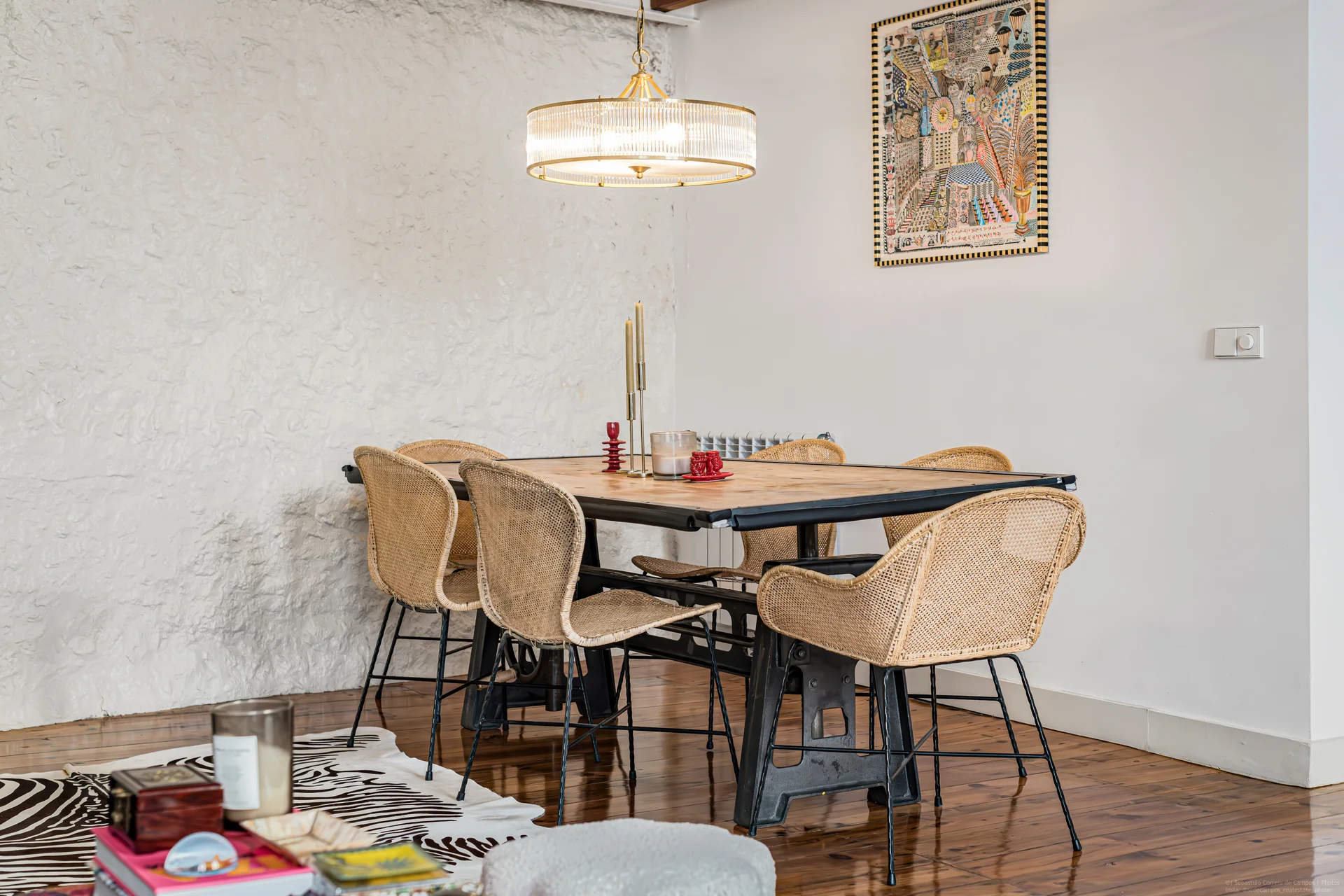 Dining table with rattan chairs under chandelier