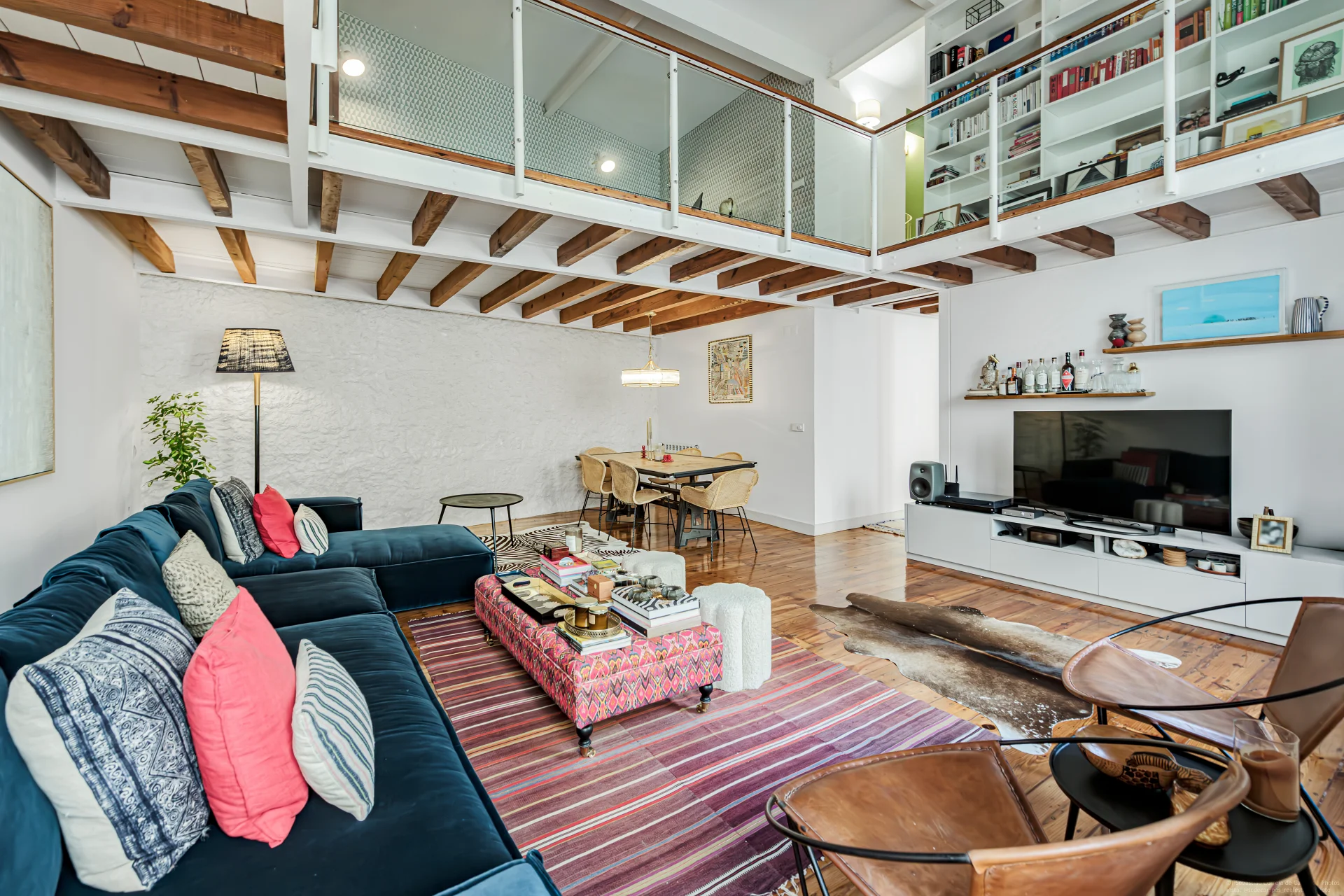 Living room with exposed beams and mezzanine