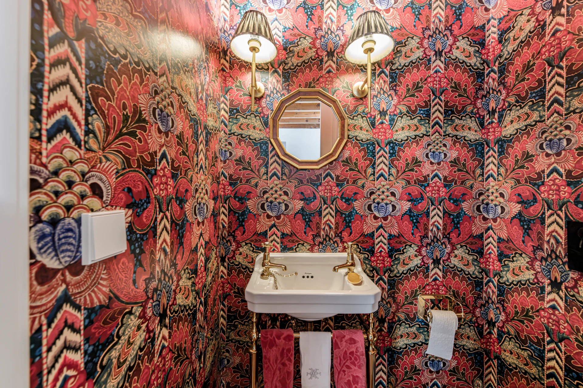 Powder room with bold floral wallpaper